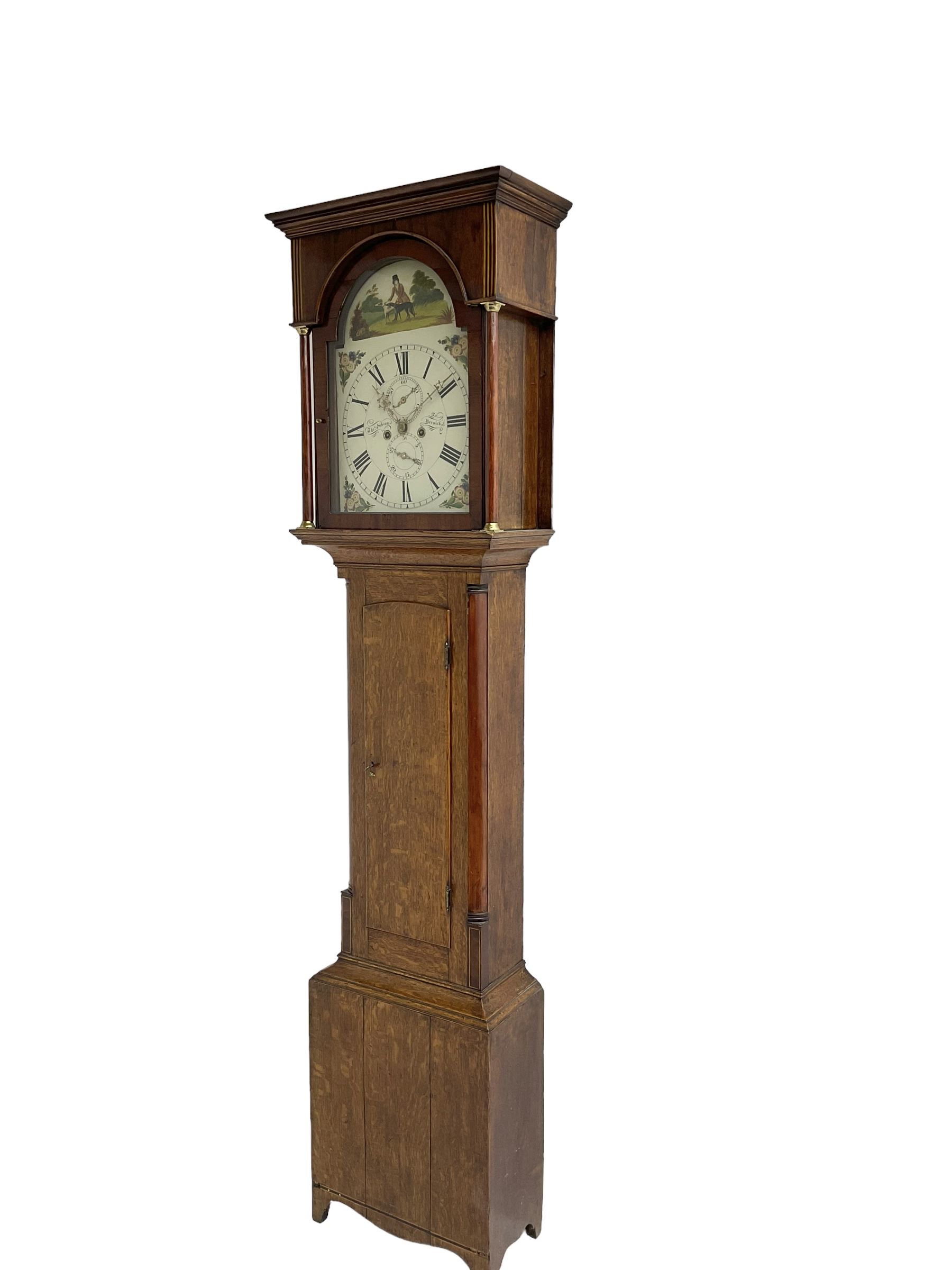 Thomas Gibson of Berwick - oak and mahogany 8-day longcase clock c 1860, with a flat topped pediment and recessed break arch door beneath, free standing pilasters with brass capitals, trunk with quarter columns to the corners and a wavy topped door, on a rectangular oak plinth with a shaped base,  painted dial with floral spandrels and a sporting scene to the break arch, Roman numerals, minute track and subsidiary seconds and date dial's, matching stamped brass hands pinned via a false plate to a rack striking movement, striking the hours on a bell. With weights, pendulum and key.   