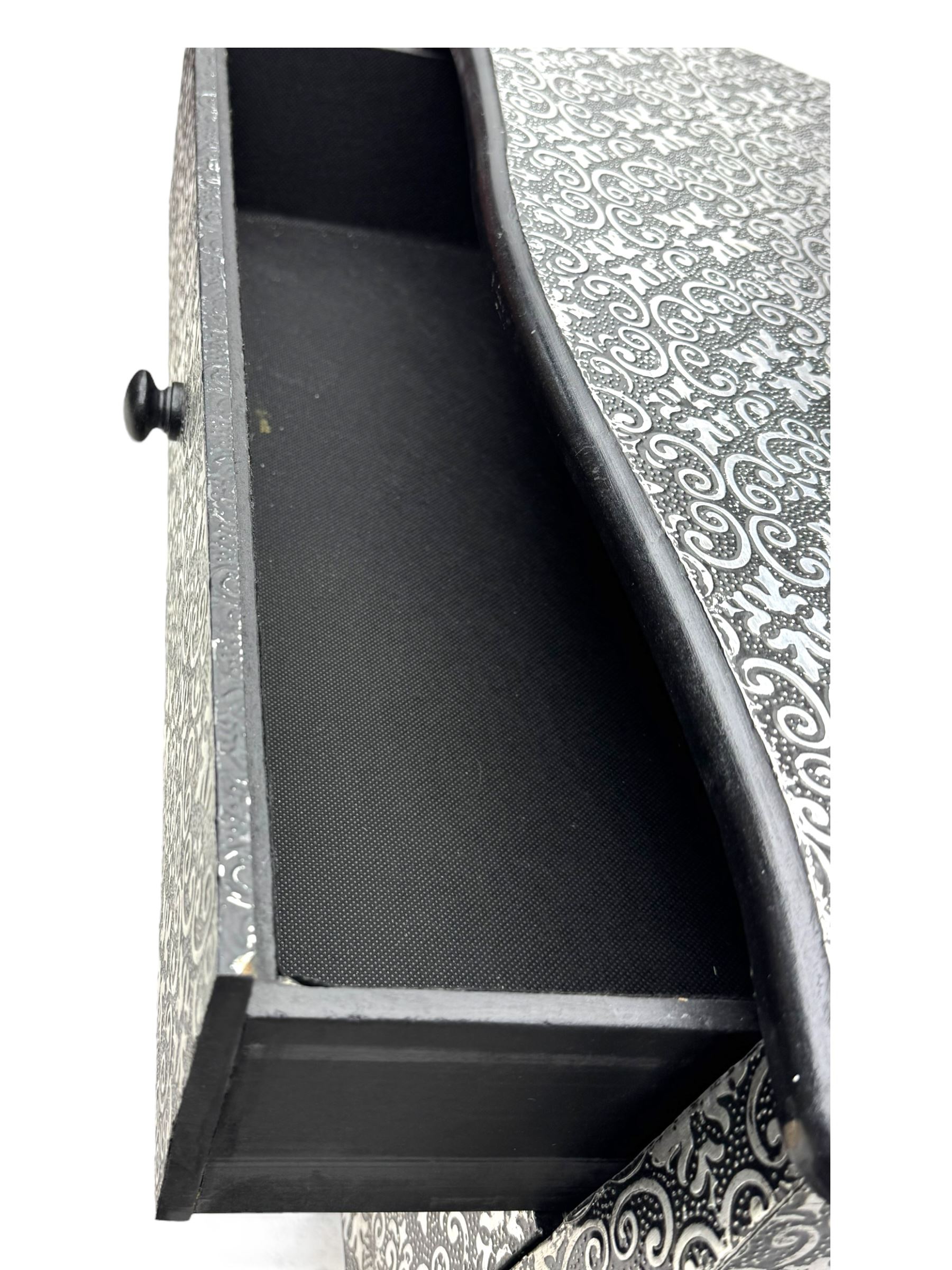 Contemporary black lacquered metal-clad chest, embossed with silver floral scrollwork, shaped rectangular top over three drawers, on cabriole supports (W89cm, D40cm, H79cm); matching two drawer chest (W68cm, D35cm, H67cm)