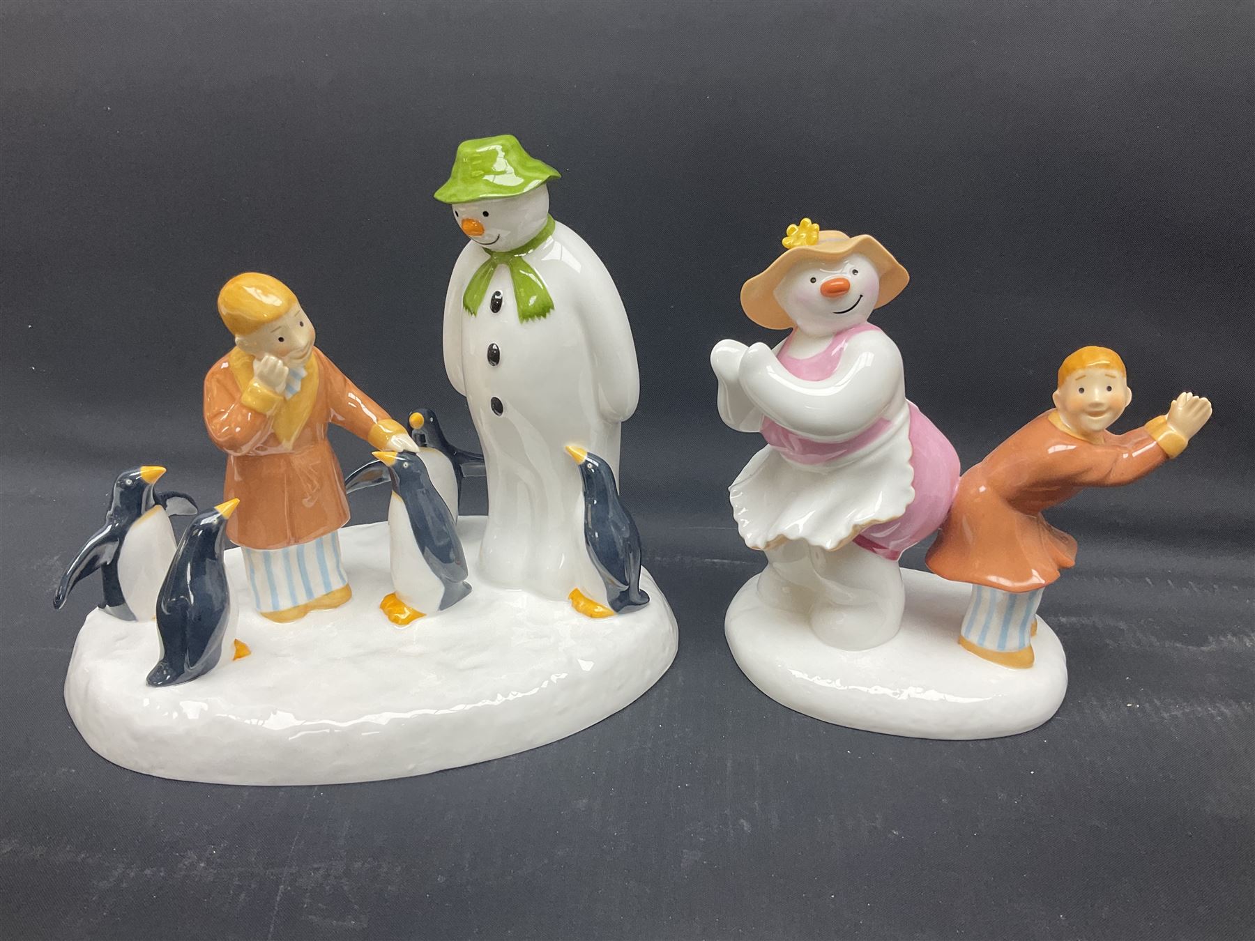 Four Coalport Characters The Snowman figures, comprising Dancing the Night Away with certificate, Penguin Pals, with certificate, Dressing Up and Soft Landing, all with original boxes 