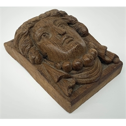 An oak furniture or architectural detail of oblong form carved in high relief with the head of a lady wearing a bead necklace and draped earrings, L9cm H13cm.