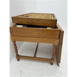 Large collection of Meccano, including perforated strips, wheels, cogs, nuts and bolts, various Meccano instruction manuals and magazines, all housed within a modified wooden box, with three tiered compartmentalised sections and upon four twist legs, box H60cm