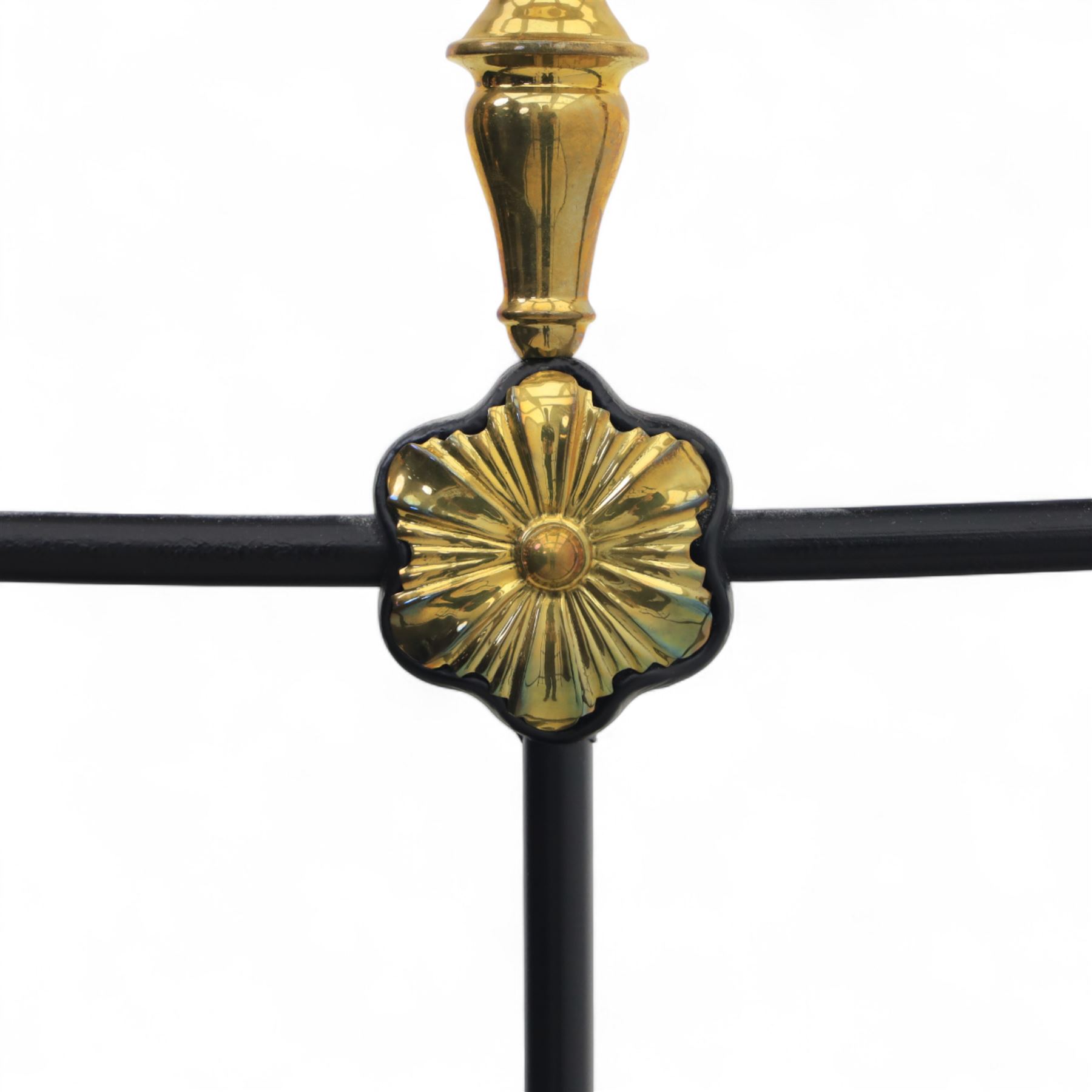 Victorian brass and iron 4' 6'' double bedstead, curved brass top rail with cast iron spindles and ornate floral rosettes flanked by urn shaped finials, foldable divan style base upholstered in a striped fabric, supported on turned posts and ceramic castors