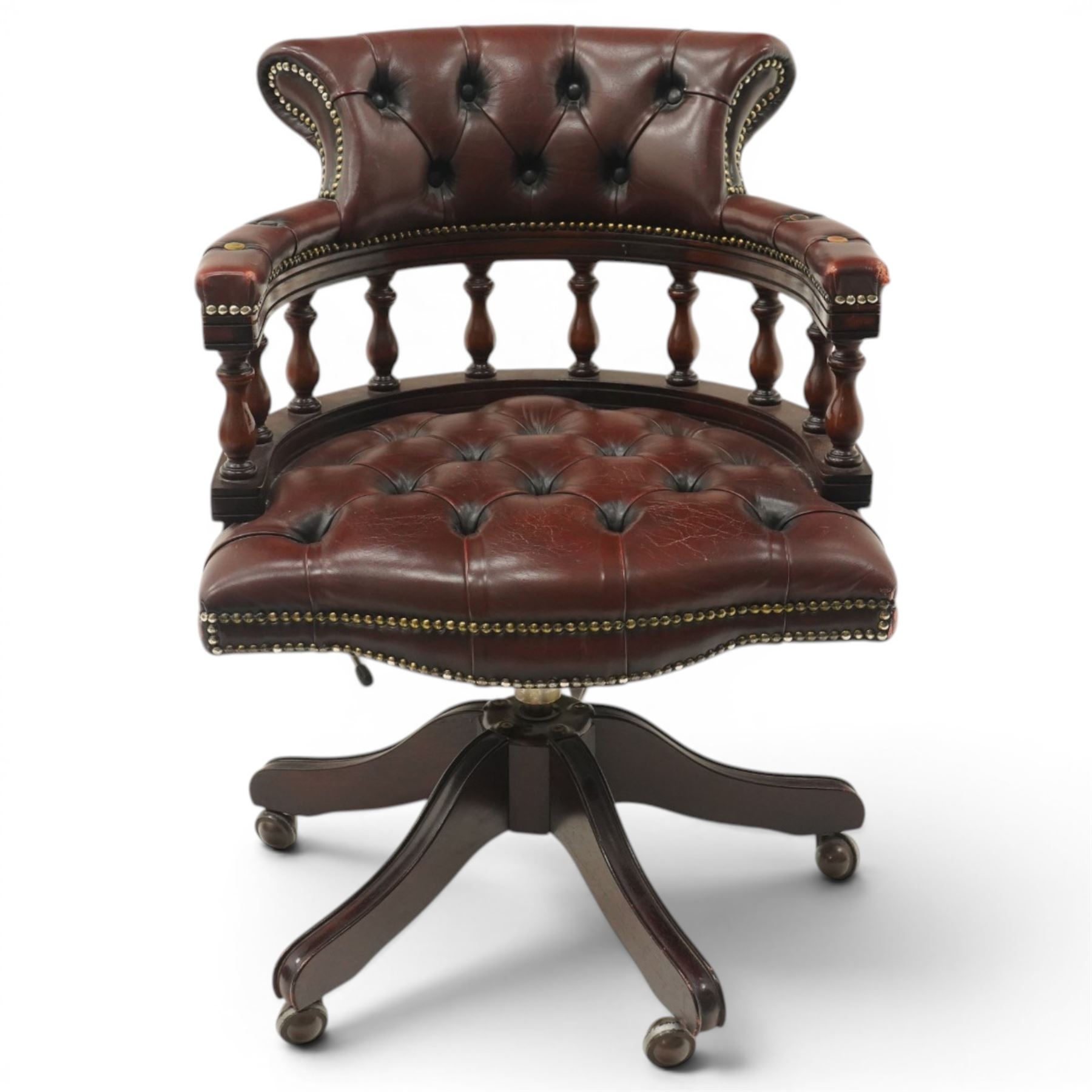Georgian design captains swivel desk chair, rolled cresting rail over open spindle back on tripod base, upholstered in buttoned oxblood leather