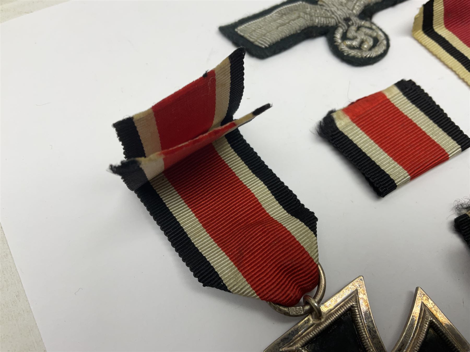 WWII German Iron Cross 2nd Class, the suspension ring stamped 128 for S. Jablonski G.m.b.H. Posen; with ribbon; together with an embroidered cloth eagle badge and quantity of German medal ribbons.