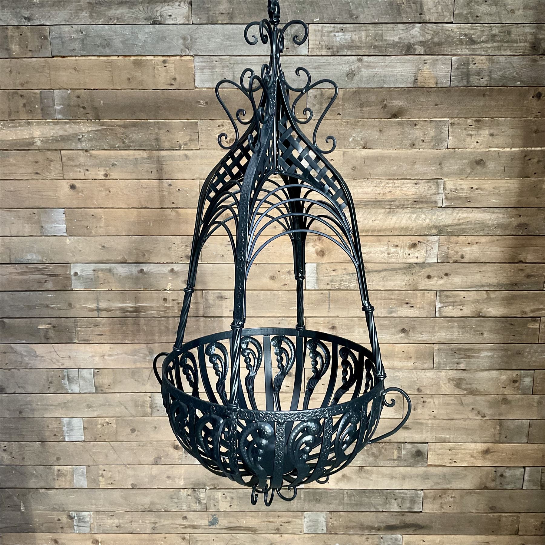 Pair of black finish wrought metal hanging baskets, with brackets