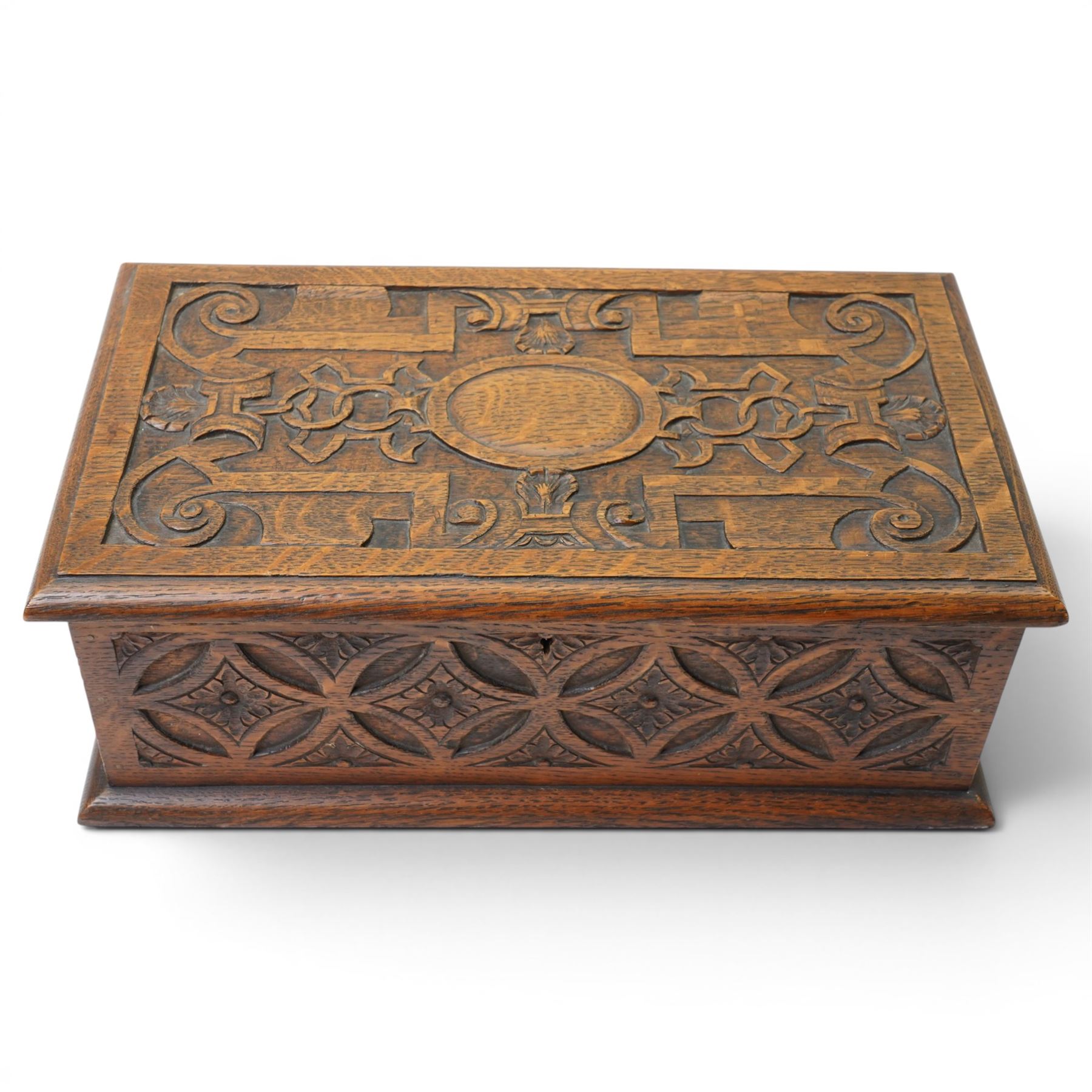 Elizabethan Revival style oak bible box, the central oval boss surrounded with carved strapwork and scrolled decoration, each side with repeating circular motif
