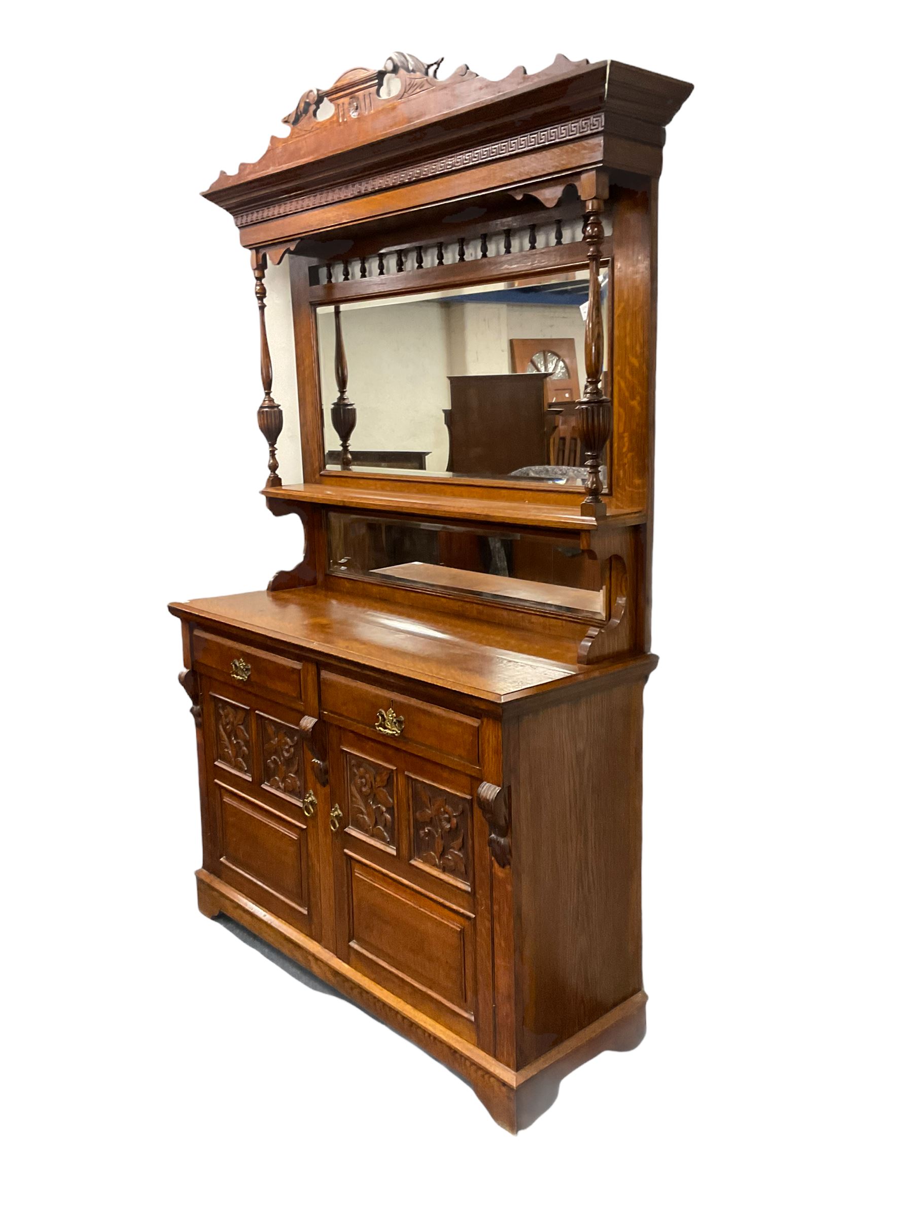 Edwardian oak mirror back sideboard, raised shaped pediment carved with acanthus leaves over Greek key frieze, bevelled mirror back, fitted with two drawers and two cupboards