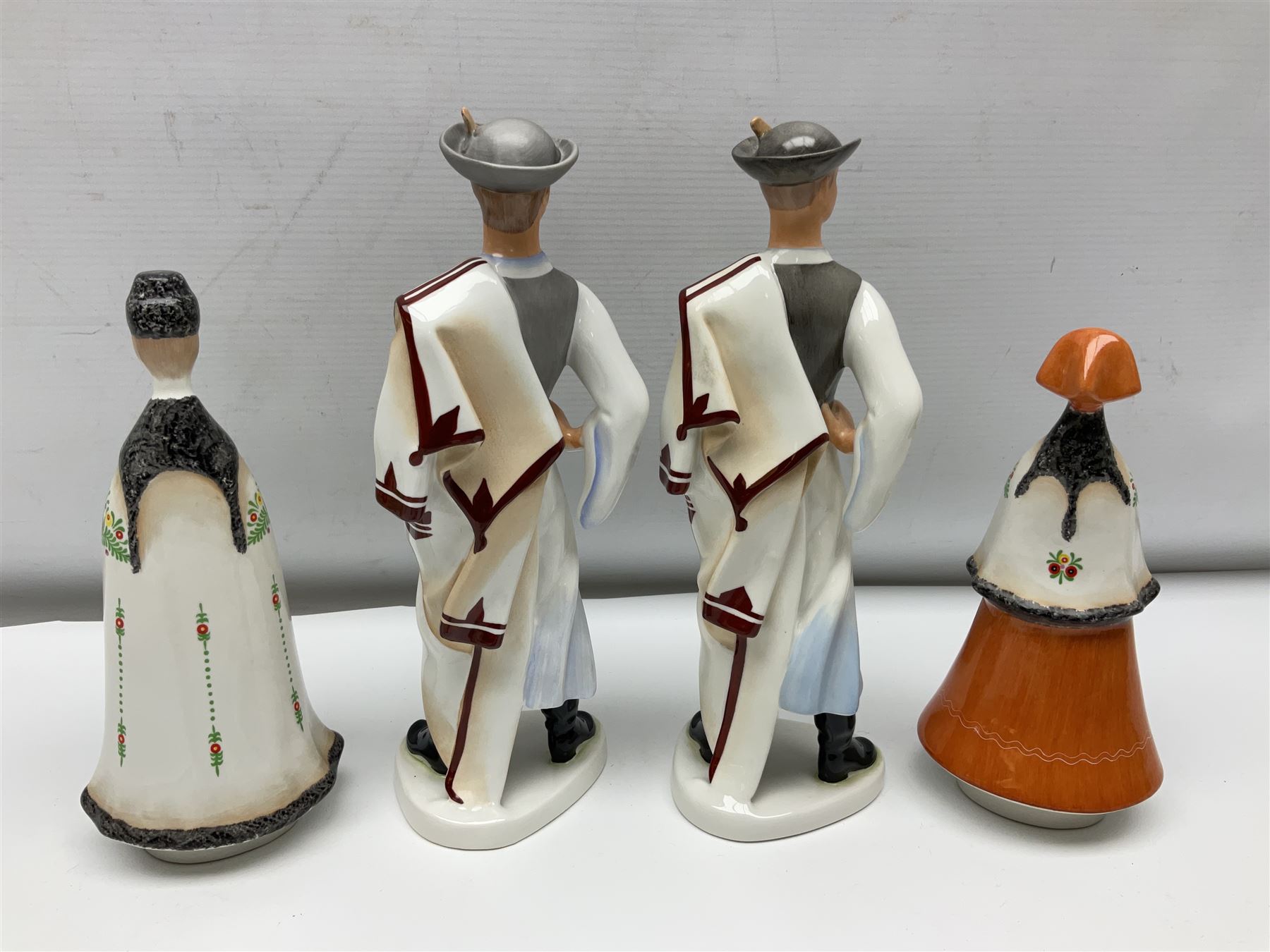 Group of eleven Aquincum of Budapest figures, comprising two of a man in a feather hat, seven dwarves, man and woman in traditional dress, all with printed marks beneath