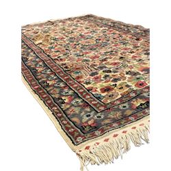 Persian design ivory ground rug, the busy field decorated with interlacing branches and flower head, three band border with repeating floral design 