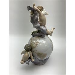 A Lladro mantel clock modelled as a globe with inset clock, surmounted by four putti and floral garlands, with blue printed mark and impressed 5973 beneath, H29cm.