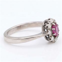 White gold ruby and diamond cluster ring, single oval cut ruby of approx 0.45 carat, surrounded by eight single cut diamonds, stamped 18ct, total diamond weight approx 0.15 carat