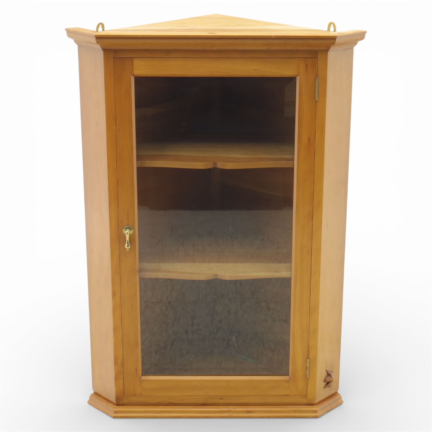 Unicornman - glazed oak corner cabinet, the triangular top with moulded cornice above a bevelled glass door, enclosing two fixed shelves, the canted front corner carved with Unicorn motif, by Geoff Gell of Coxwold