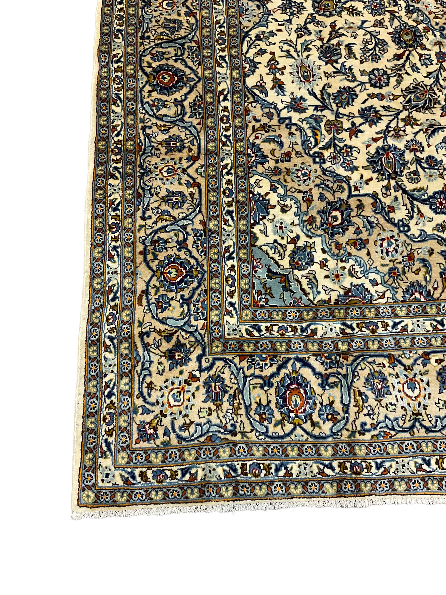 Persian Kashan ivory ground carpet, the field decorated profusely with interlacing branch and stylised plant motifs, scrolling border with overall floral design 