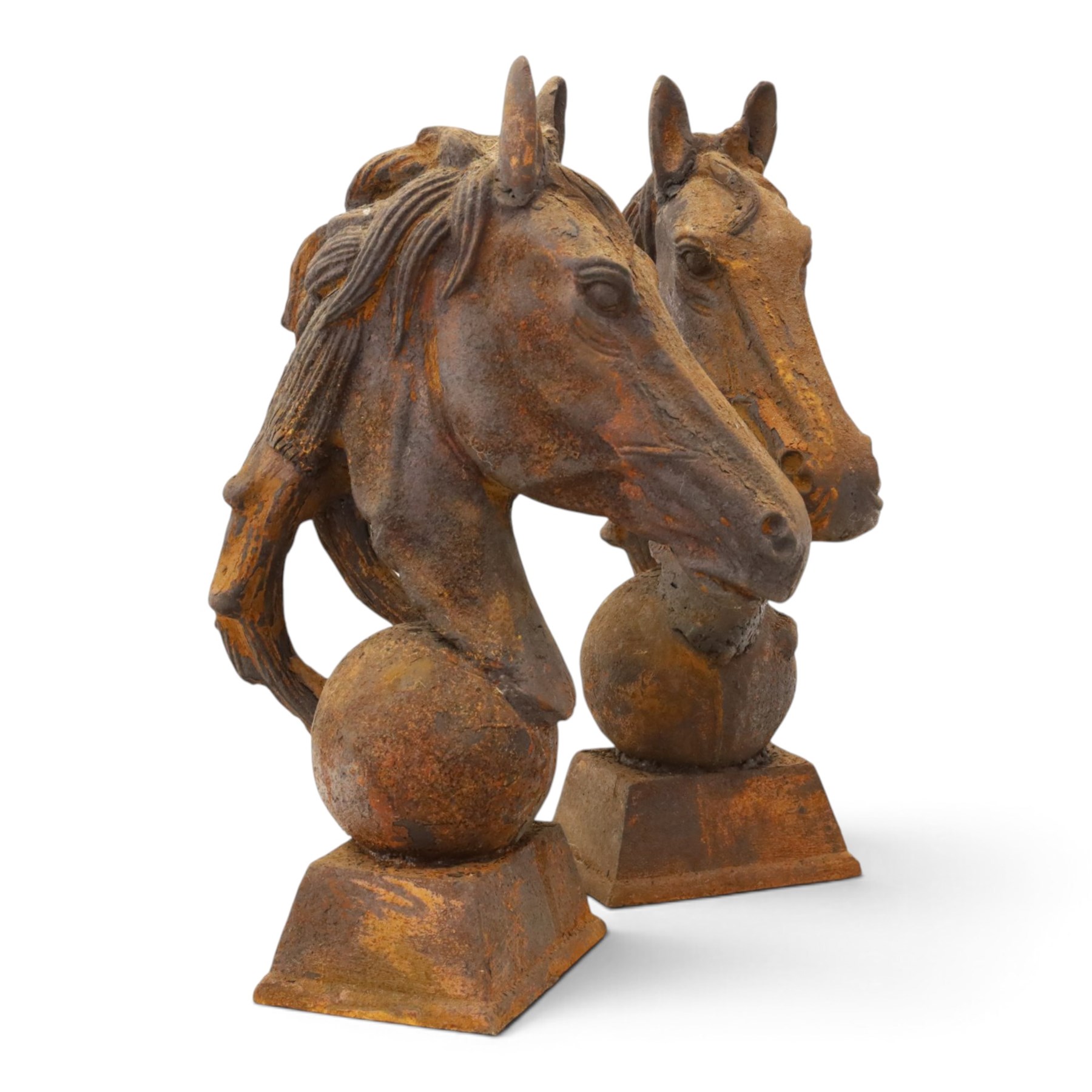 Pair of antique cast iron garden finials or statues of horse heads or busts, the heads with flowing and pierced mane, mounted on spherical finials over square tapering bases