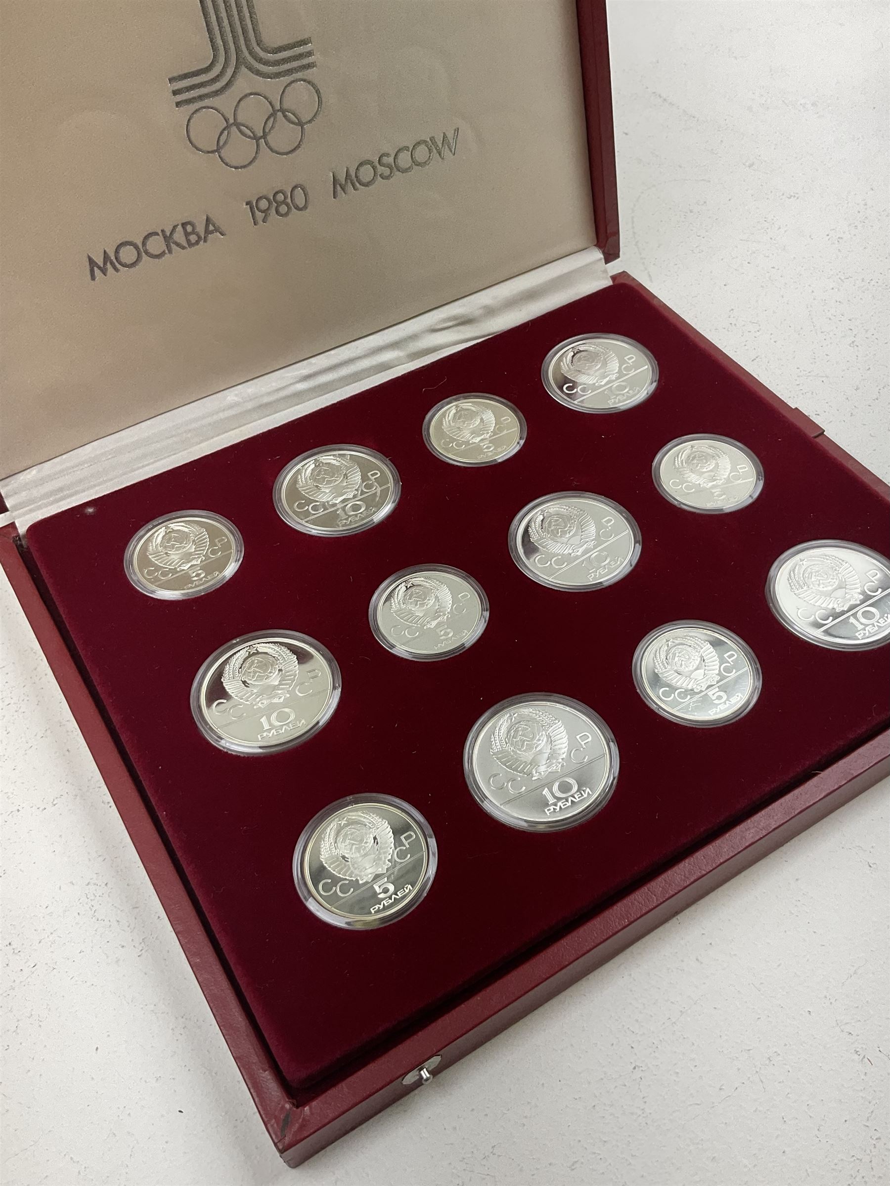 Russian 1980 Moscow Olympic Games silver twenty eight coin set, housed in dated red case and four other coins relating to the Olympics, housed in dated black case