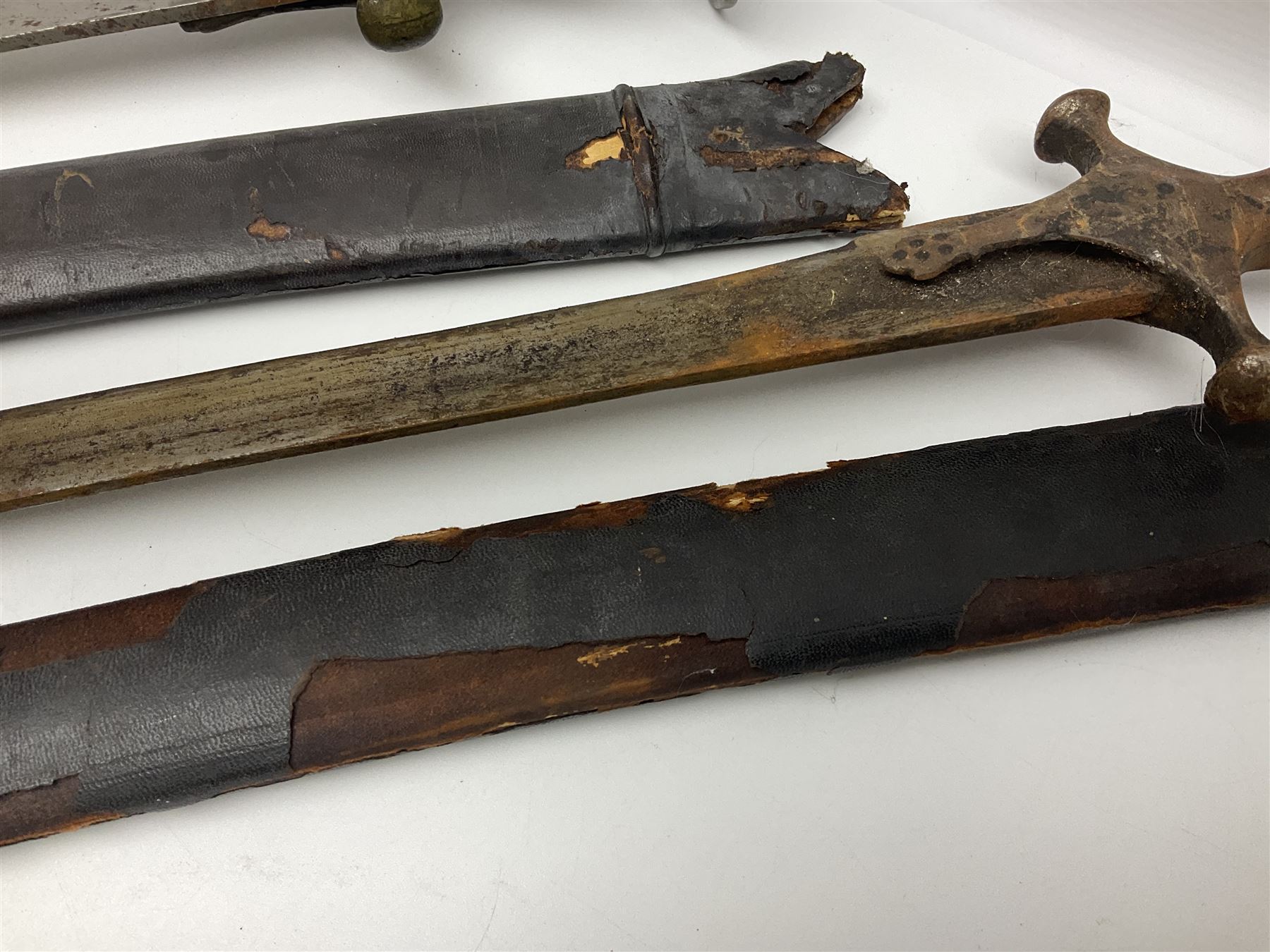 Four Indian tulwar swords; three with cast brass hilts and one with iron hilt; longest blade 81cm; all with scabbards (4)
