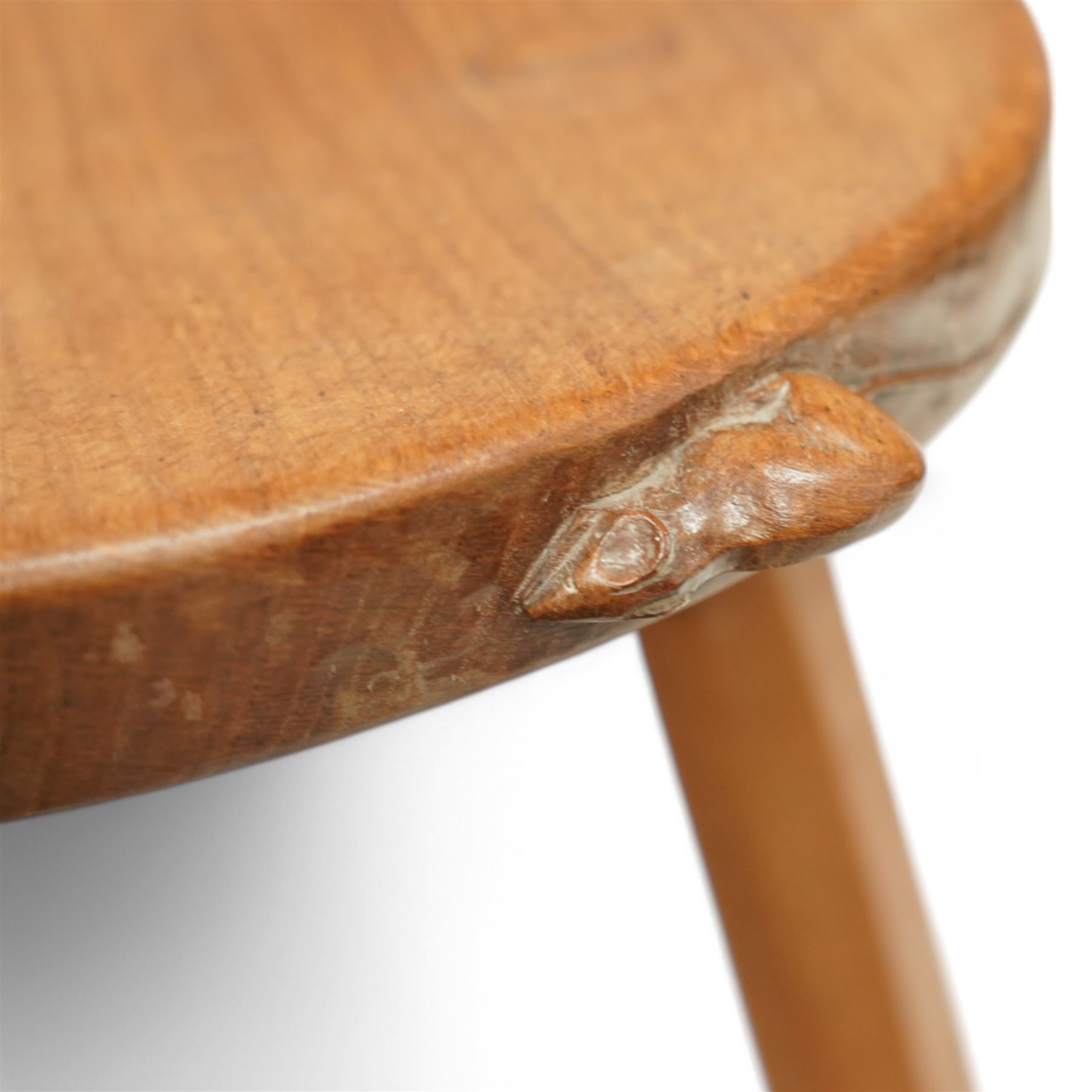 Mouseman - oak three-legged stool, dished kidney-shaped seat on three octagonal splayed supports, carved with mouse signature, by the workshop of Robert Thompson, Kilburn