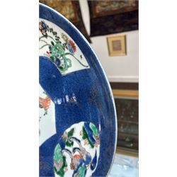 Chinese powder blue ground famille verte charger, possibly Kangxi, decorated with a central cartouche enclosing two female figures, with smaller shaped panels enclosing lions and foliage, square seal mark in blue to base, D28cm