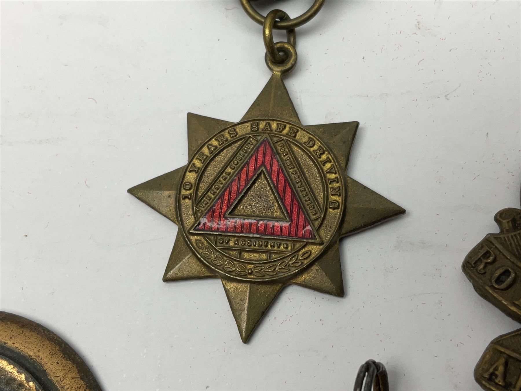 Made-up group of three WWI medals comprising 1914 Star awarded to 23598 Gnr. F. Jefferson R.G.A., British War Medal and Victory Medal with names removed; with ribbons on wearing bar; 1942 Motorist's Medal and small quantity of cap badges, Royalty badges etc