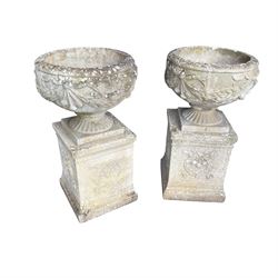 Pair of quality Neoclassical design Haddonstone cast stone garden urns, the globular  body decorated with relief foliate festoons and fruiting motifs, over a fluted socle, the rectangular pedestals with relief foliate wreaths and ribbon garlands