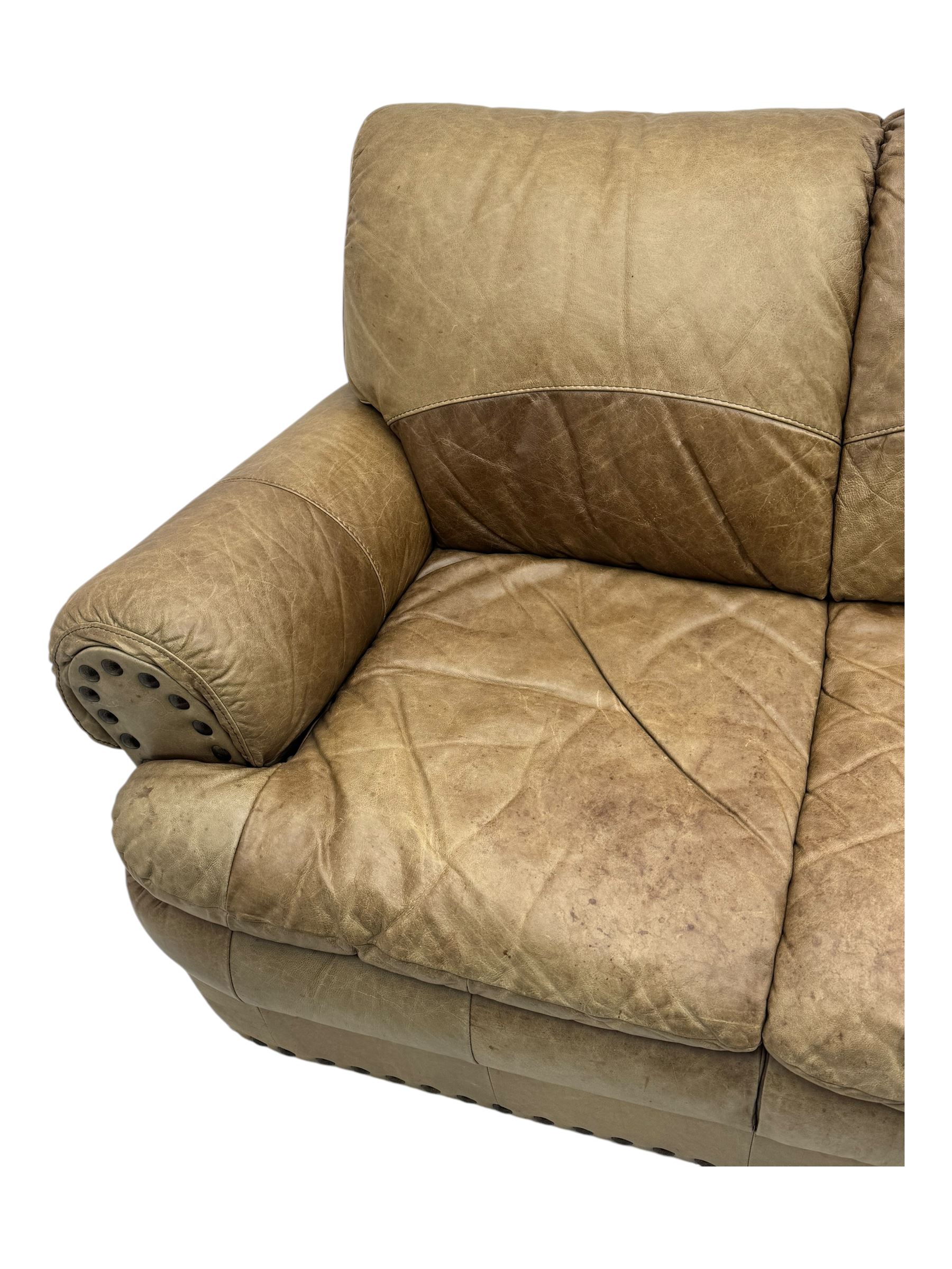Contemporary three-seat sofa, upholstered in stitched brown leather with brass studwork decoration, rolled back and arms, raised on turned supports