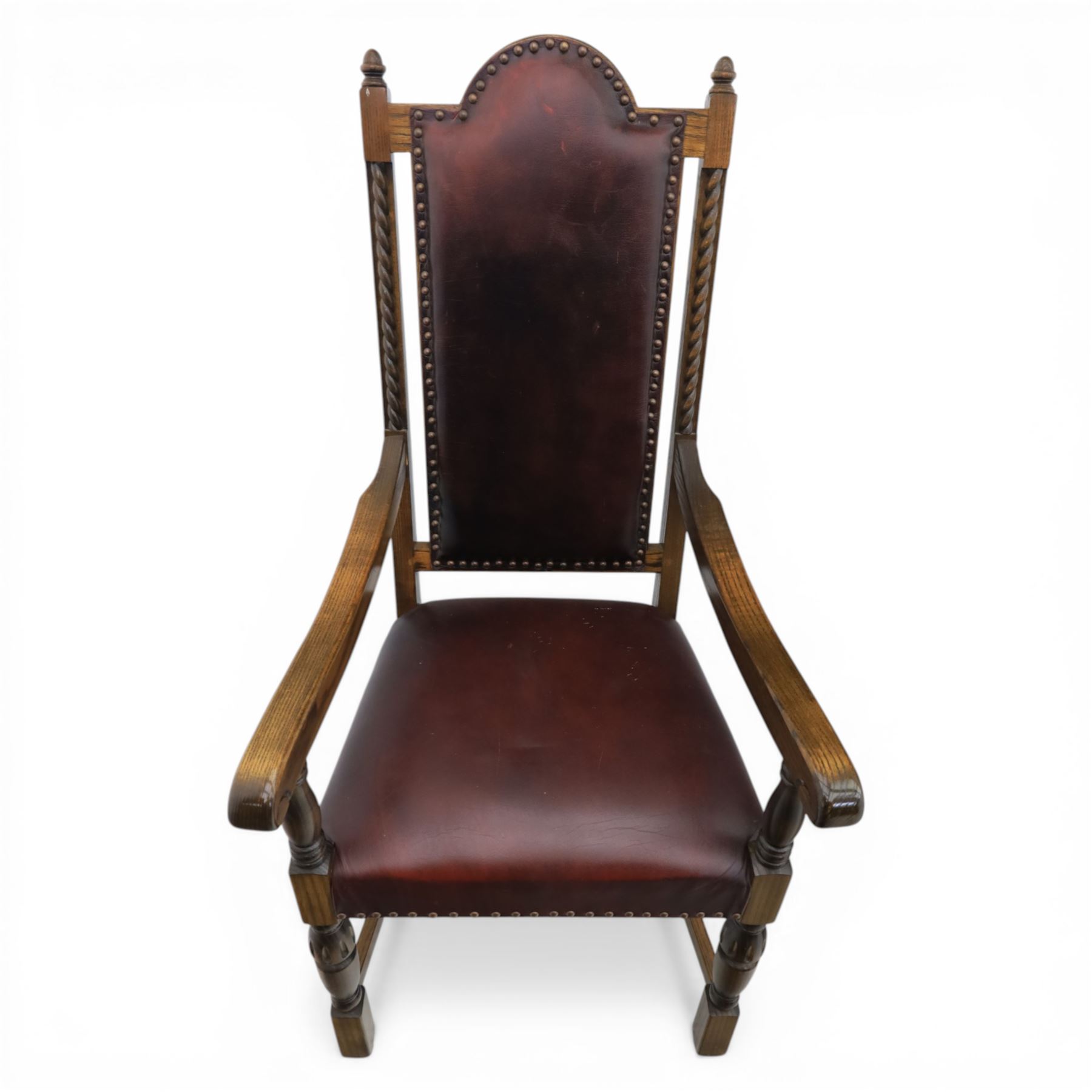 Carolean revival oak dining table and eight chairs (7+1), refectory table with rectangular boarded top and cleated ends, raised on shaped trestle end supports with central stretcher, accompanied by eight high-back chairs including a carver, leather upholstered panels and seats with studwork, on turned legs with stretchers.