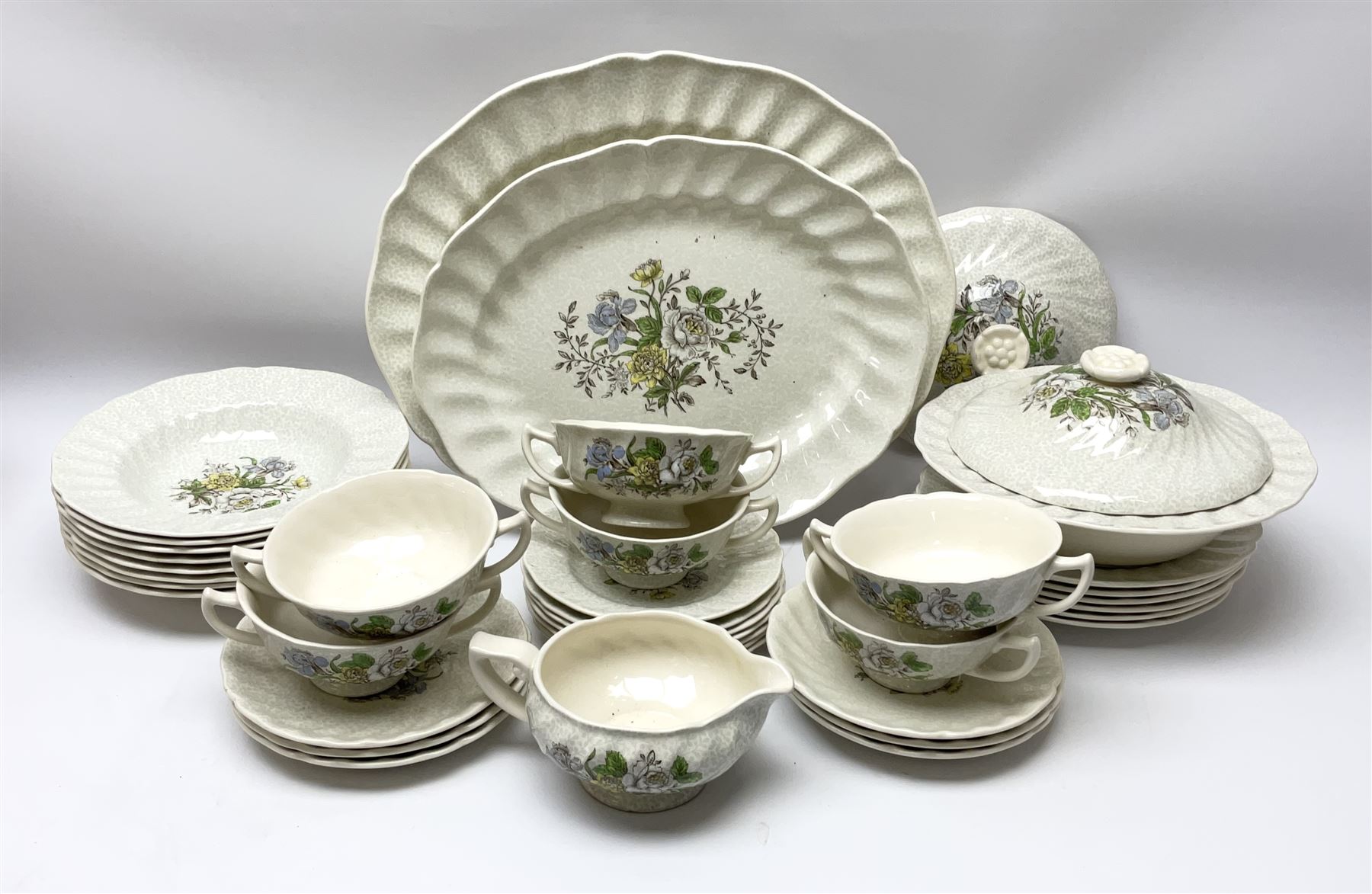 Royal Doulton dinner wares decorated in the Sutherland pattern, comprising two serving platters, one tureen and cover, six twin handled soup bowls and saucers, eight bowls, six dinner plates, seven side plates, and jug. 