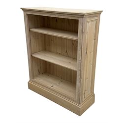 Contemporary light pine open bookcase, rectangular top with stepped moulded edge above a boarded back, fitted with two adjustable shelves, on a plinth base