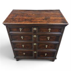 Late 17th century moulded front oak chest of drawers, rectangular plank top. above two banks of four graduated drawers, central escutcheons and drop handles, on squat bun feet