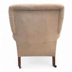Late 19th century Howard style upholstered armchair, with deep seat and scroll arms, on turned front legs with brass and ceramic castors, the rear leg stamped Smith & Co Bristol No.302 