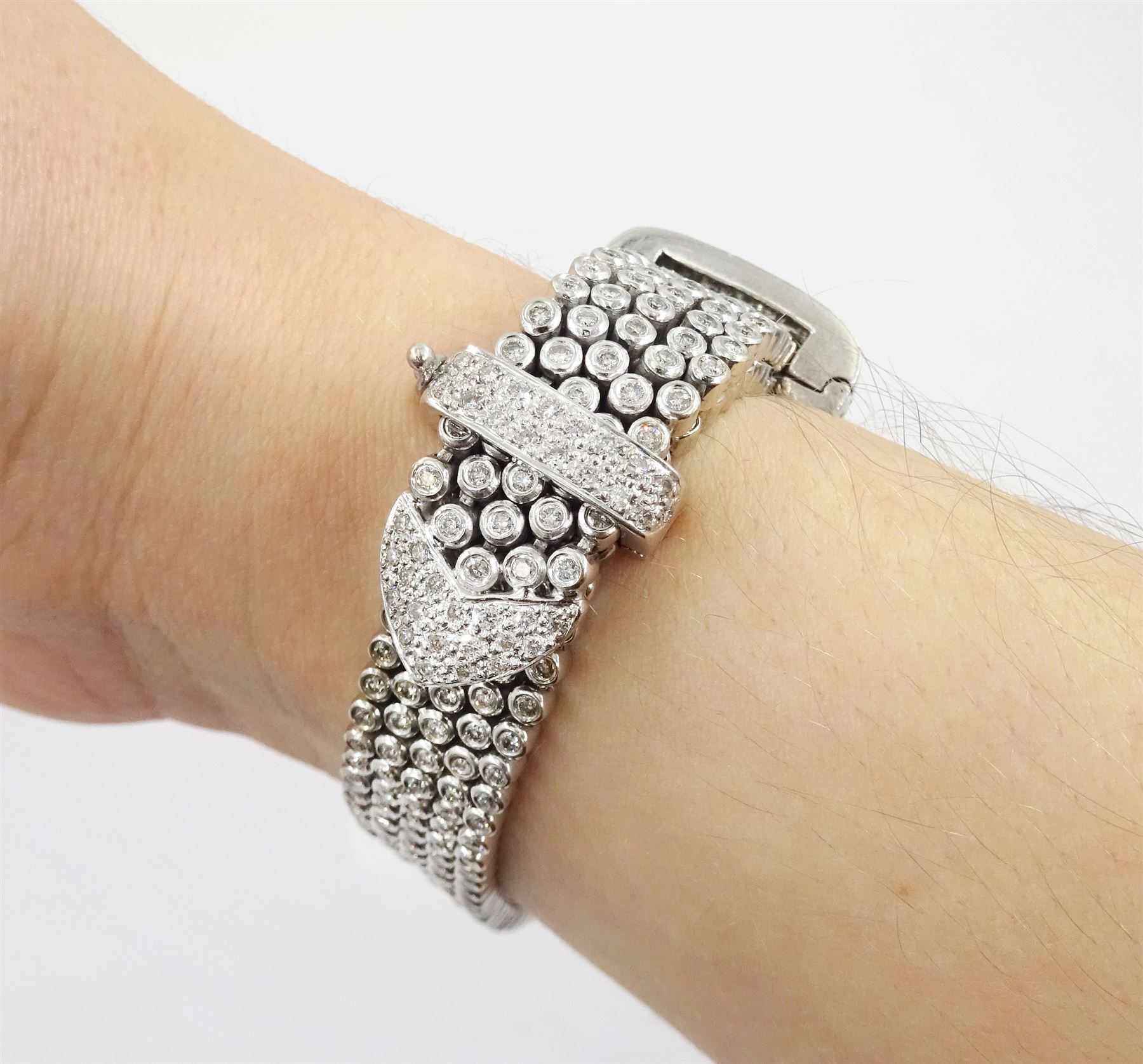 14ct white round brilliant cut diamond belt bracelet, the bracelet with rubover set diamonds, the buckle and clasp with pave set diamonds, stamped 14K, total diamond weight 5.35 carat