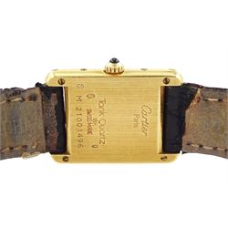 Cartier Tank ladies 18ct gold quartz wristwatch, back case No. M 21001496, white dial with Roman numeral hour markers, on black leather strap with 18ct gold buckle, both by Cartier, hallmarked