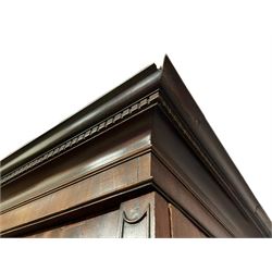 George III mahogany double wardrobe, the projecting cornice with dentil moulding over two panelled doors with mirror-lined interiors, enclosing hanging rails and brass hooks, the base fitted with two drawers, raised on bracket feet