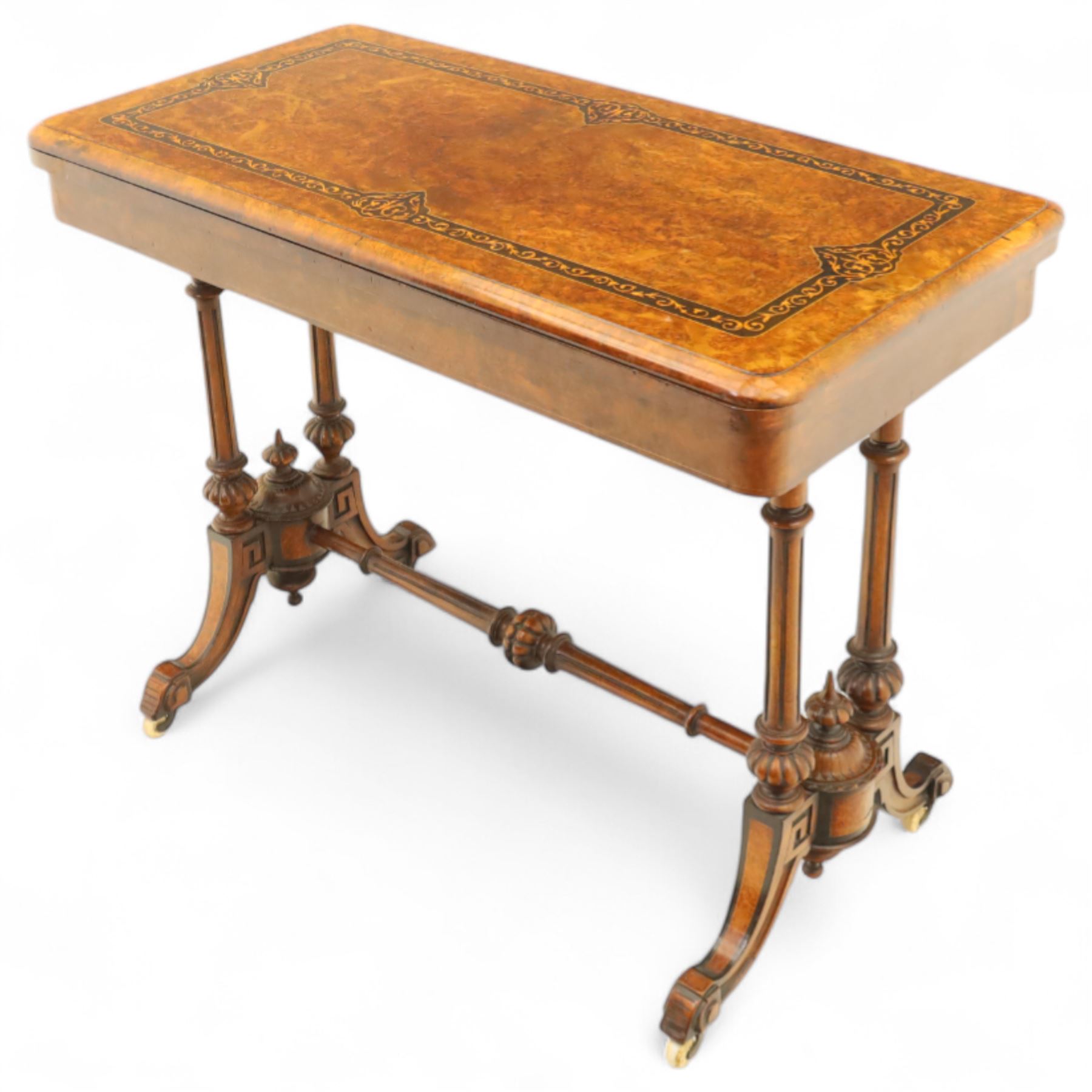 Victorian walnut and inlaid games table, rectangular fold-over top with figured walnut veneers and foliate inlay, swivel and fold over to reveal a green baize lined playing surface, on twin supports united by a stretcher, raised on scroll carved feet with castors (extended 96cm x 92cm)