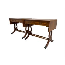 Pair yew wood drop leaf stretcher side or sofa tables, fitted with two drawers, on lyre shaped ends with splayed moulded supports joined by turned stretchers, hairy paw castors