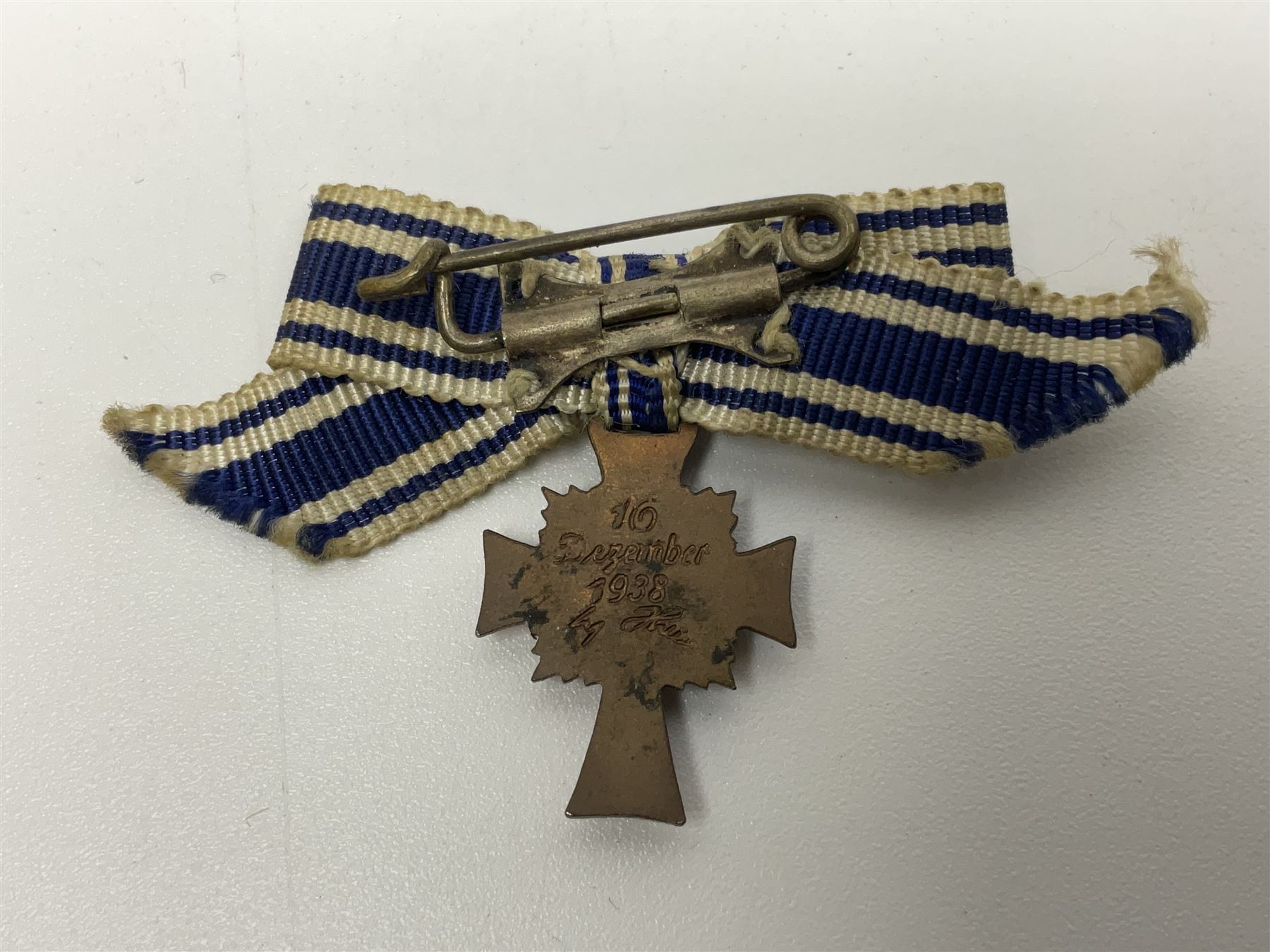 Four German awards - pre-WW2 two-position button hole ribbon for 1914 Iron Cross; WW1 wound badge open back cut-out version with silvered finish; miniature version Mother's Cross with ribbon bow; and The Eastern Medal, officially the Winter Battle in the East 1941–42 Medal (4)