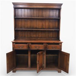 Georgian style oak dresser, the moulded cornice above two open plate racks, upon base with rectangular top above an arrangement of three frieze drawers fitted with brass swan neck handles, and three panelled cupboard doors, upon bracket feet
