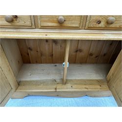 Early 20th century pine kitchen dresser, featuring a hutch with arched top over three open shelves, the base with five drawers over three cupboard doors, turned column supports flanking the doors, scalloped apron base with bracket feet
