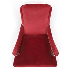 Victorian walnut framed reading open armchair of reclined position, the high sprung back and deep seat upholstered in crimson fabric with matching loose seat cushion, turned arm terminals over turned feet terminating to brass castors