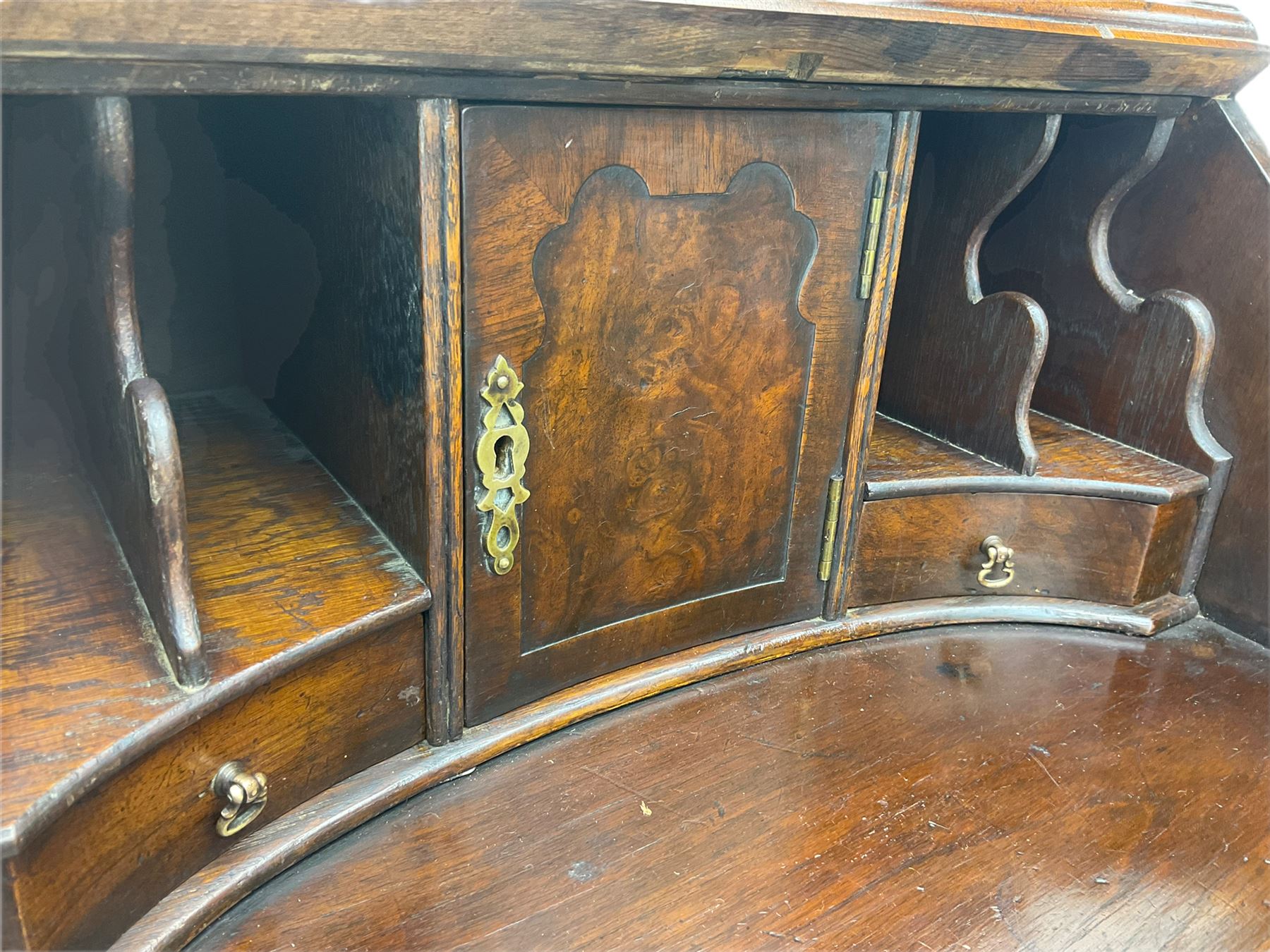 Small early 20th century Queen Anne style bookcase on bureau secretaire, the moulded arched pediment over mirrored door in shaped frame, the bureau fitted with fall front enclosing curved fitted interior, cushion moulded drawer over single drawer, on scroll and shell carved cabriole supports