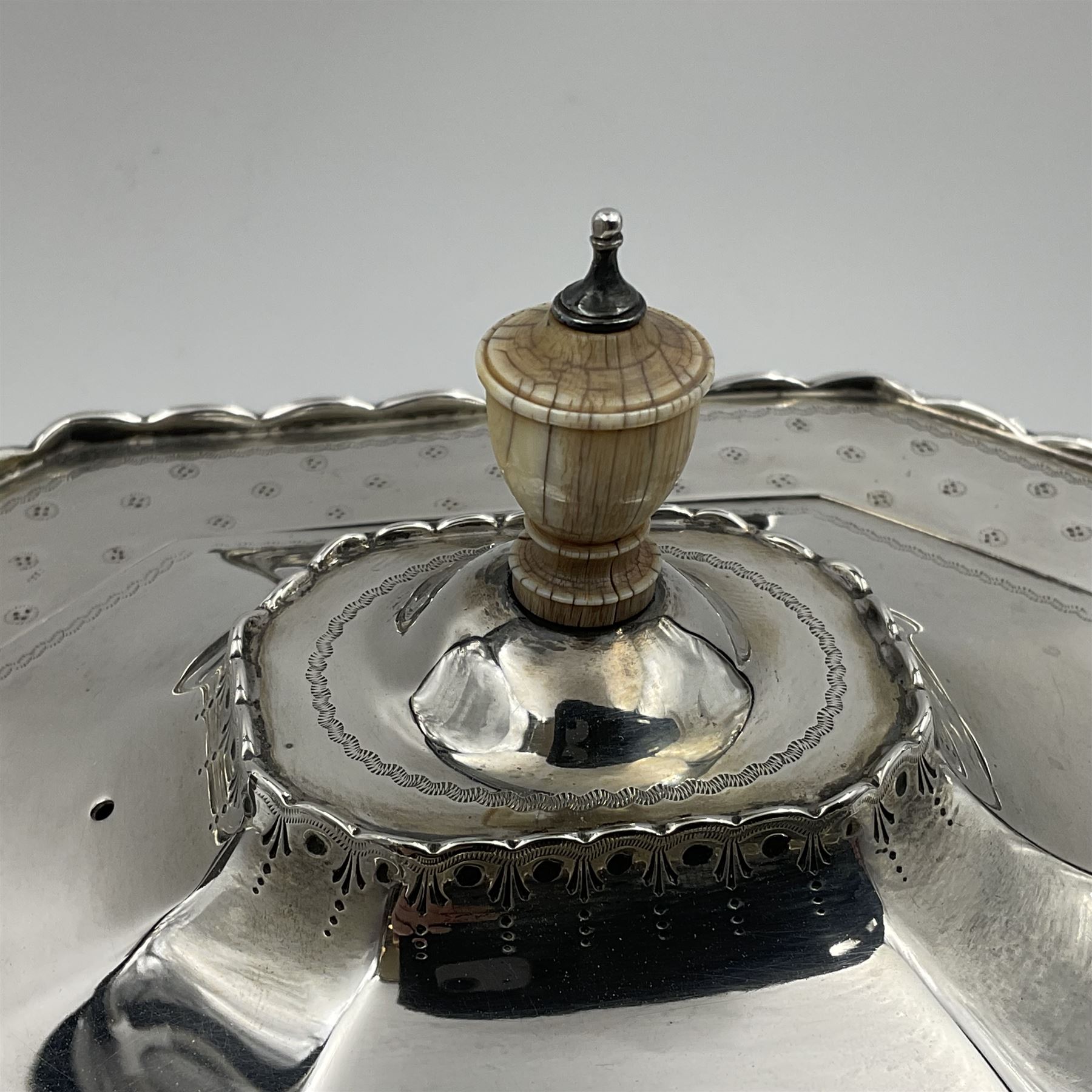 Victorian silver four piece tea service, comprising teapot, teapot stand, twin handled open sucrier and milk jug, each of octagonal form with foliate bud border and engraved decoration including crest to canted panels, and vacant panels, the teapot with ivory finial to the hinged cover and later wooden handle, hallmarked Edward Barnard & Sons Ltd, London1896, teapot including finial H15cm, milk jug including handle H16cm, teapot stand W11.5cm

This item has been registered for sale under Section 10 of the APHA Ivory Act