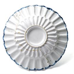 18th century Dutch Delft plate of fluted design decorated in blue and white with figures in a landscape D29cm and a Dutch Delft vase decorated in blue and white with oriental flowers H21cm (2)