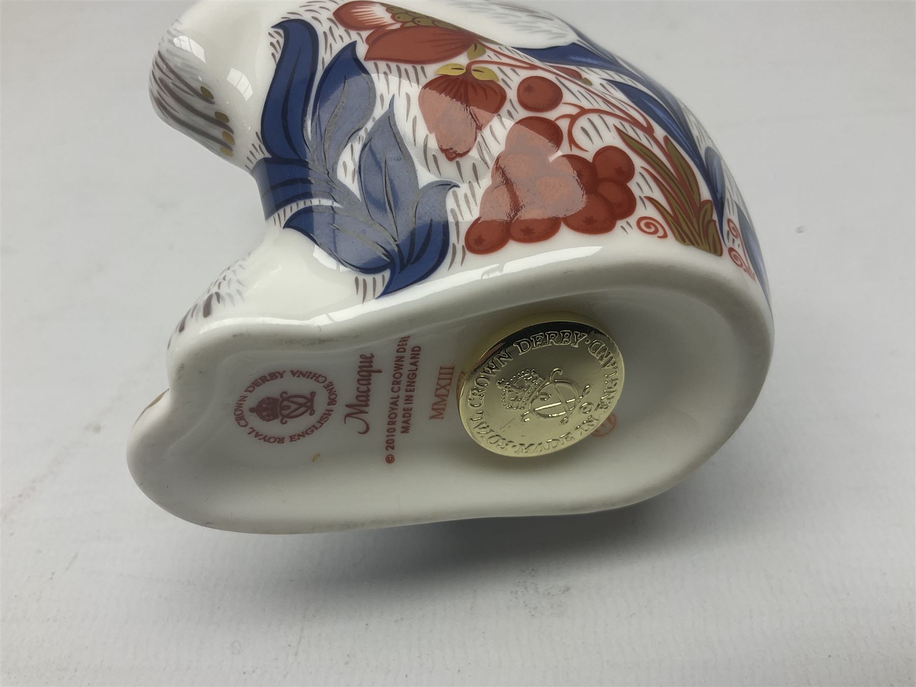 Three Royal Crown Derby paperweights, comprising Macaque, with gold stopper and original box, Monkey and Baby, with silver stopper and original box and Dragon with silver stopper, all with printed mark beneath  