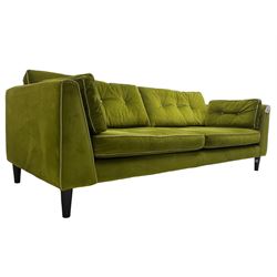 Mid-century design four seat sofa, upholstered in peridot green fabric with contrasting piping and buttons, on ebonised tapering feet
