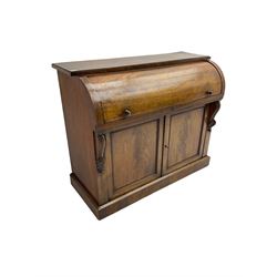 Victorian mahogany roll-top writing desk, top concealing fitted interior with pigeonholes and three drawers, the trisector inset writing surface with writing slope, base fitted with panelled cupboard enclosing single shelf, decorated with scrolled corbels