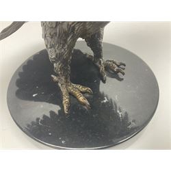 Bronze eagle, modelled in a standing position with wings spread, raised on a black veined marble circular plinth base, H29cm