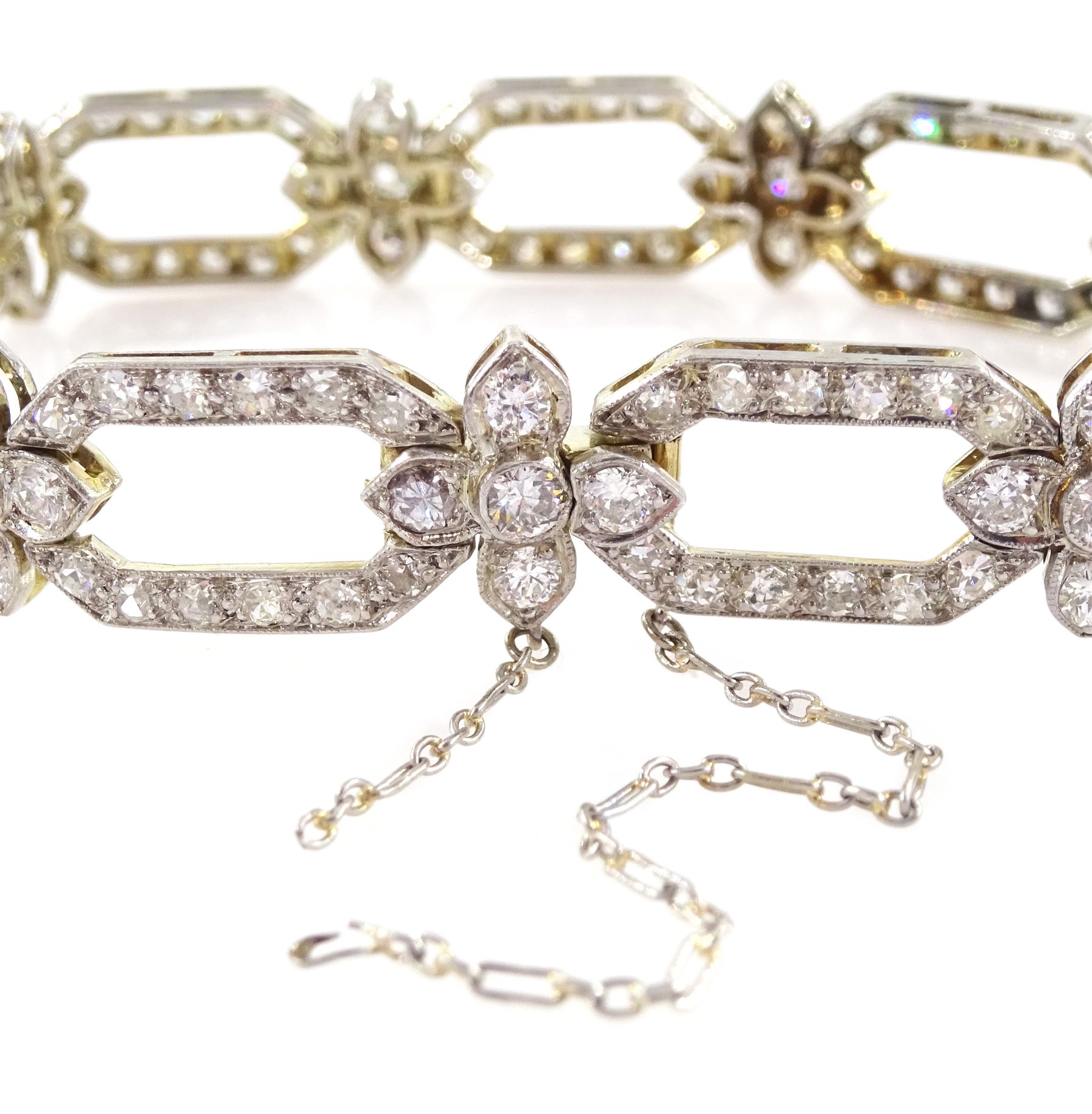 18ct white gold and platinum, milgrain set old cut diamond flower head and openwork panel link bracelet, total diamond weight approx 4.25 carat