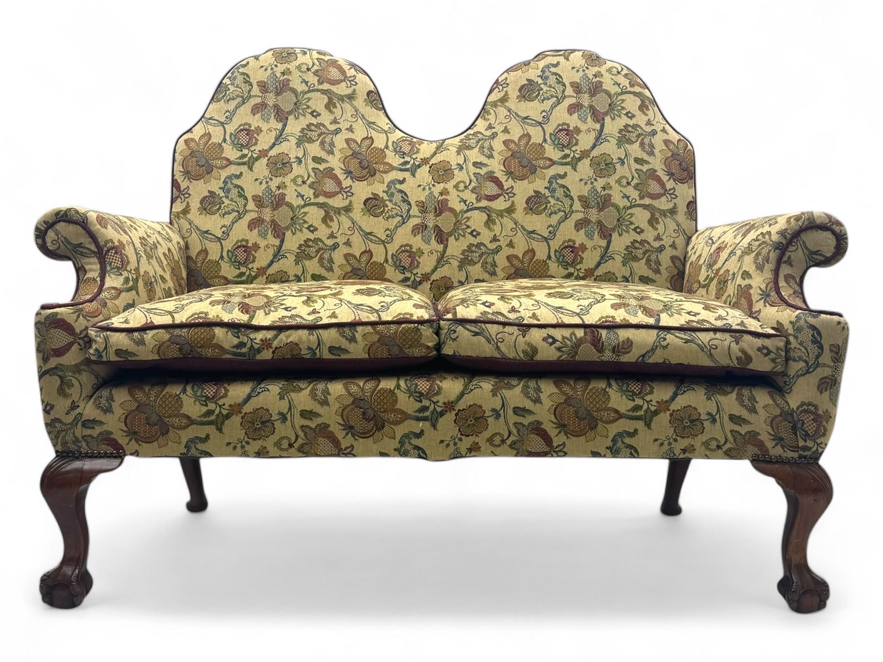 Mid-20th century William and Mary design two-seat sofa, upholstered in floral patterned fabric with contrasting piping, featuring camel-shaped back and scroll arms, on cabriole supports