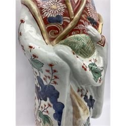 Large Japanese Imari porcelain figure, modelled as a Bijin, wearing a long kimono decorated with apple blossom and leafy branches on a white ground, with gilt detailing, possibly Edo period, H63cm