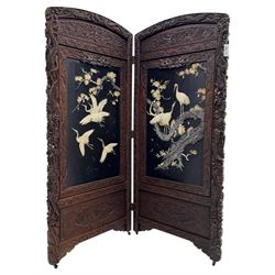 Meiji period (1868–1912), Shibayama lacquer carved hardwood two-fold screen inlaid with mother-of-pearl, bone, and ivory, decorated on one side in high relief and inlaid in a  Shibayama manner with oriental storks flying below flowering branches,  the reverse lacquer panels depicting flowering cherry trees. This item has been registered for sale under section 10 of the APHA Ivory Act.